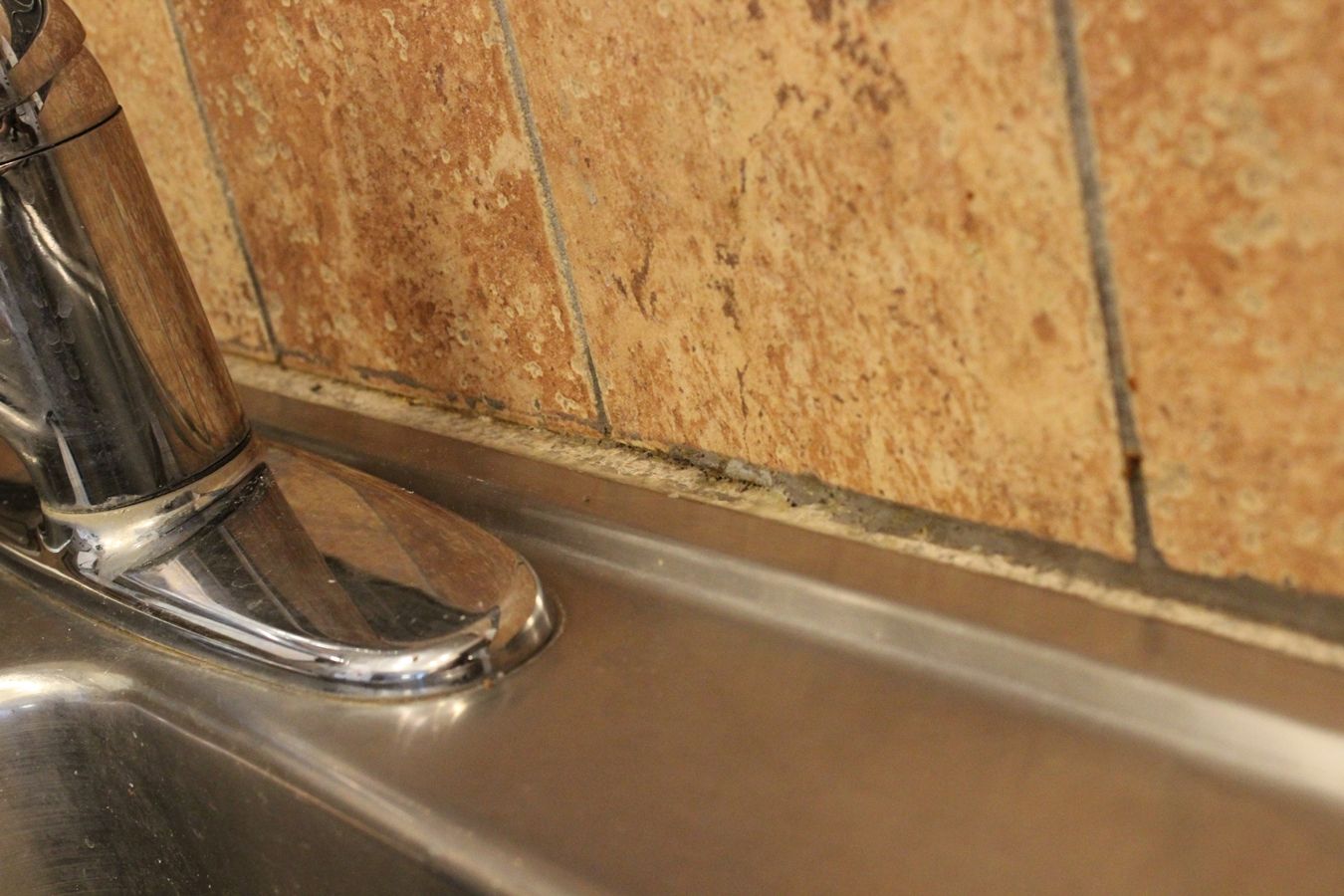 Removed loose grout behind the kitchen sink