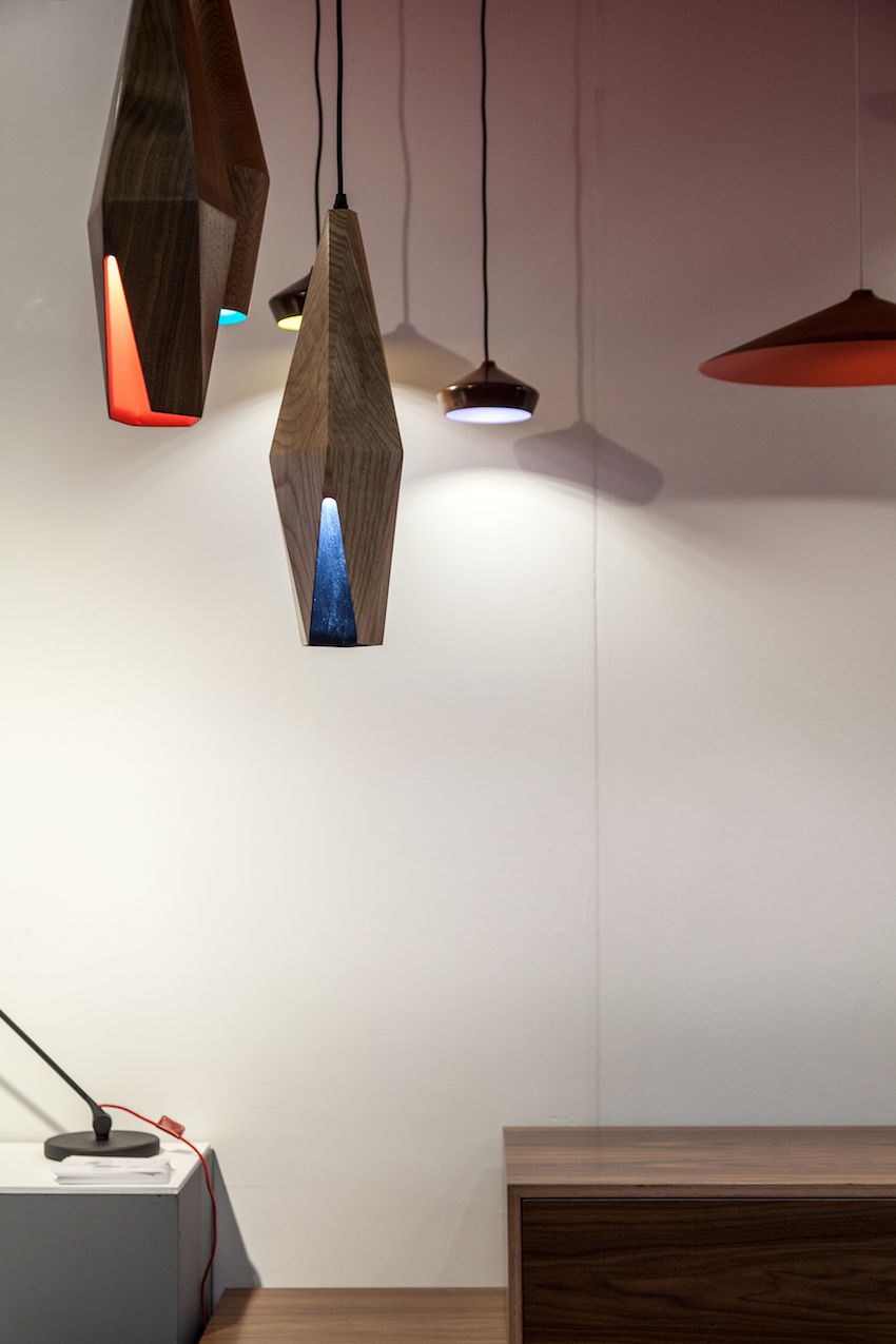 The wood grained exterior of this angular modern pendant lighting belie the colorful interior. The tapered opening at the bottom offers a glimpse of the vivd hue inside.