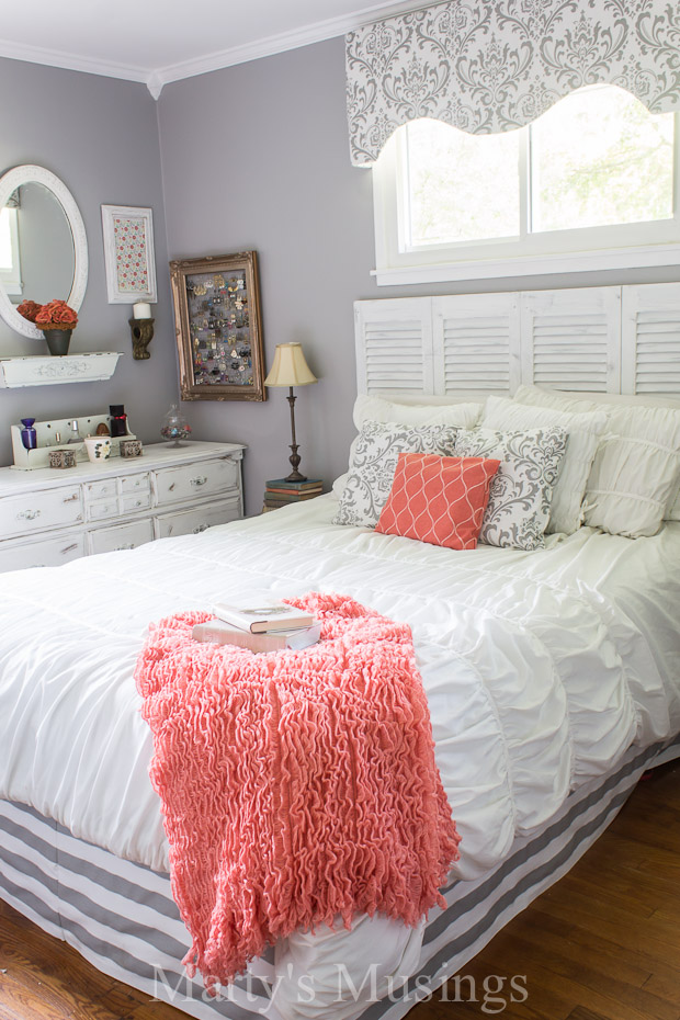 Gray and coral bedroom featuring white fluf bedding