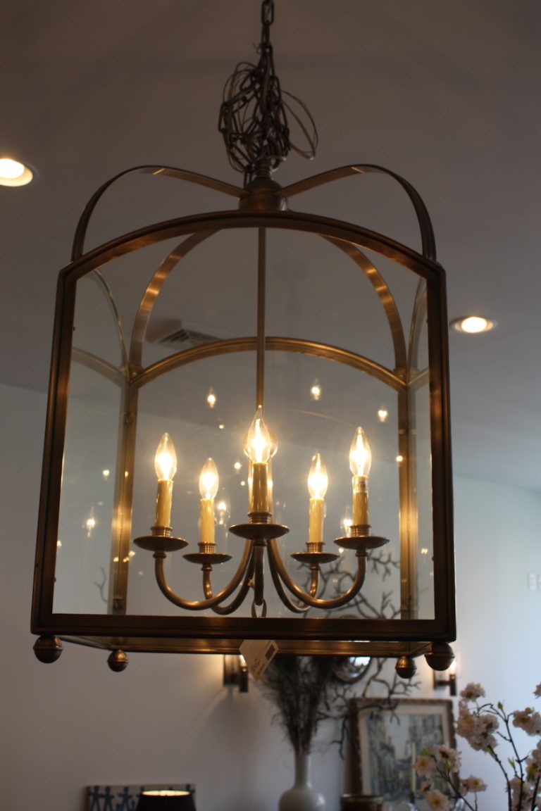 The Arch Top Lantern has five arms and features graceful curves, r in a brushed pewter finish. We love how it is a chandelier inside a glass enclosure.