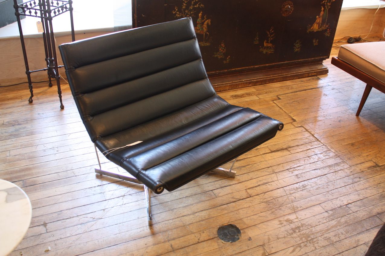 This is a classic George Nelson design -- the Catenary Leather Chair. Upholstered in black leather the set sit upon a chrome-plated steel base.