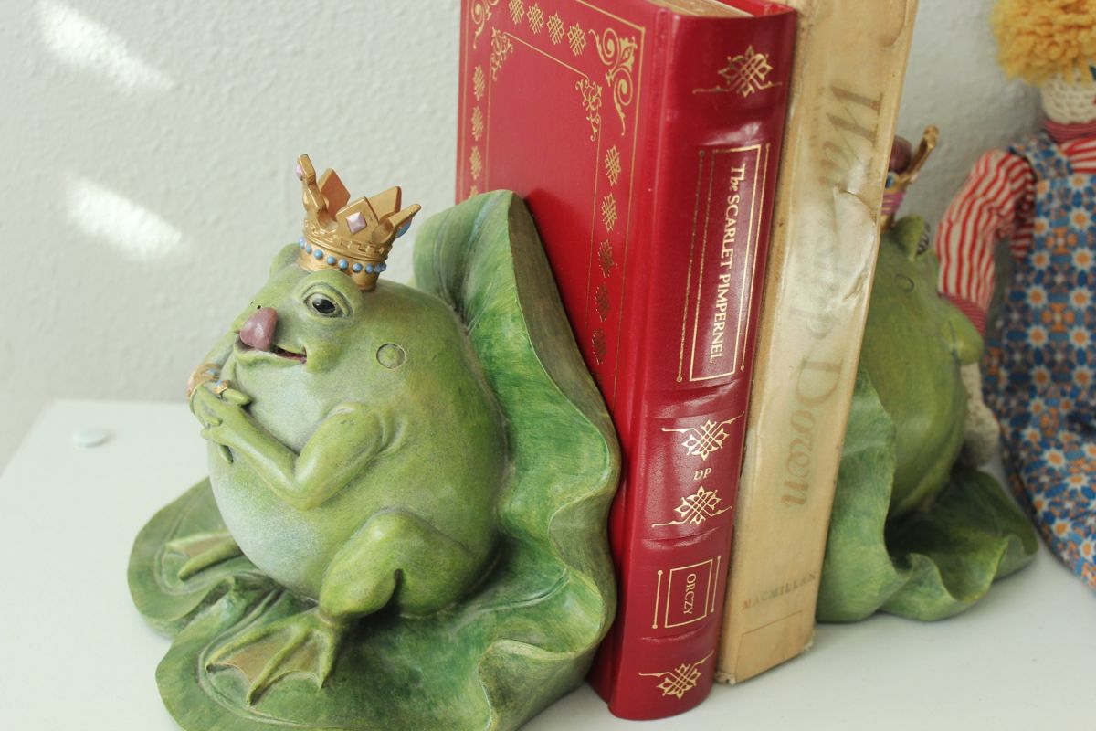 oversized frog bookends holding