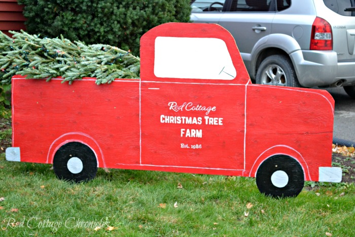 A red truck sign carrying a Christmas tree