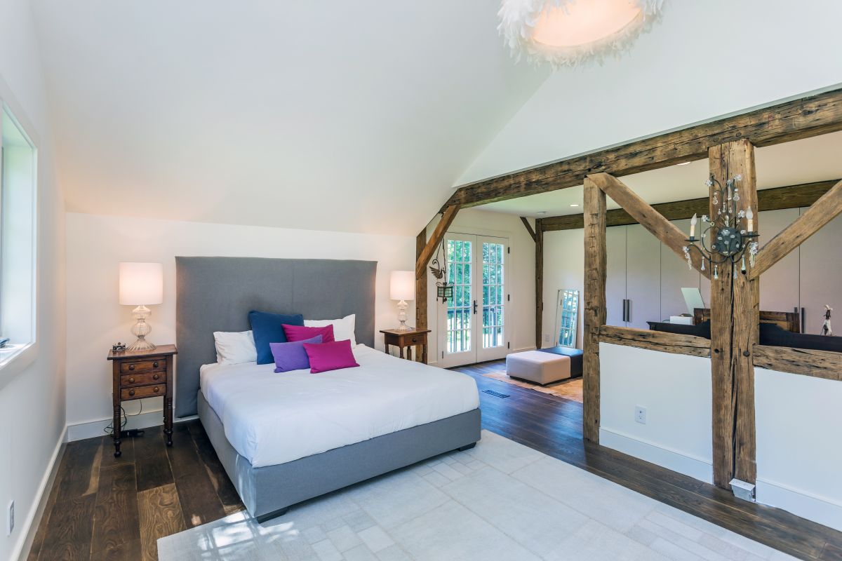 The master bedroom has access to a sitting area and takes advantage of the exposed wood