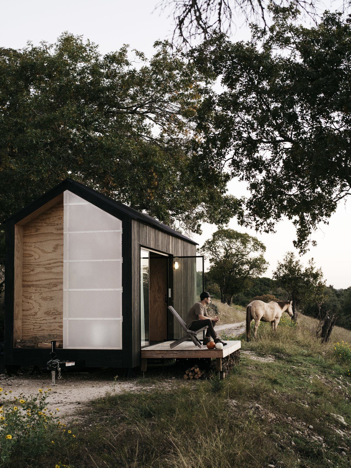 A small wooden deck acts as a connector between the cabin and the landscape