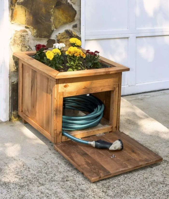 Wooden planter box with a built-in hose holder