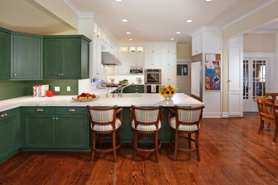 Kitchen with a double bowl sink and green cabinets with white quartz countertops