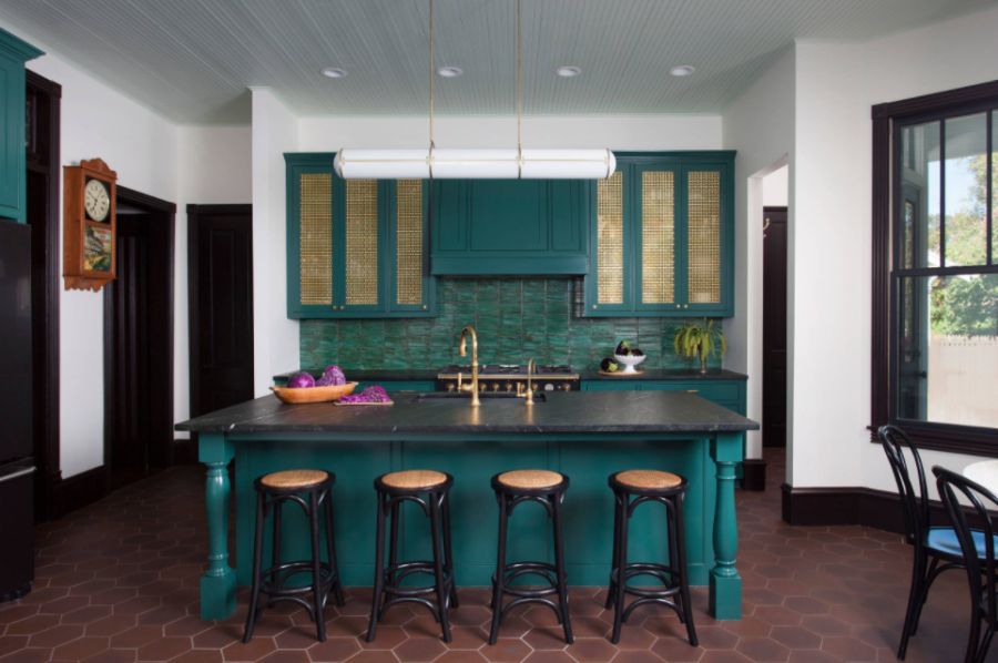 Kitchen with an undermount sink green cabinets and an island with black countertop