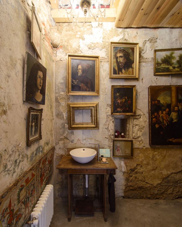 The bathroom is decorated with lots of framed paintings