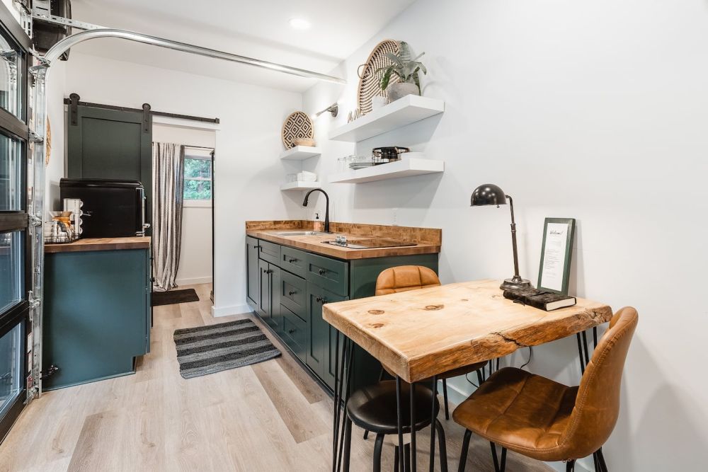 The small dining area has a beautiful table with a live edge wood top and hairpin legs