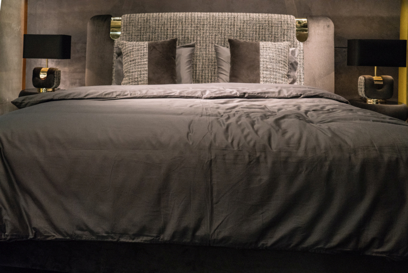 Gold Accents Connect the Headboard, Cushions, and Lamps