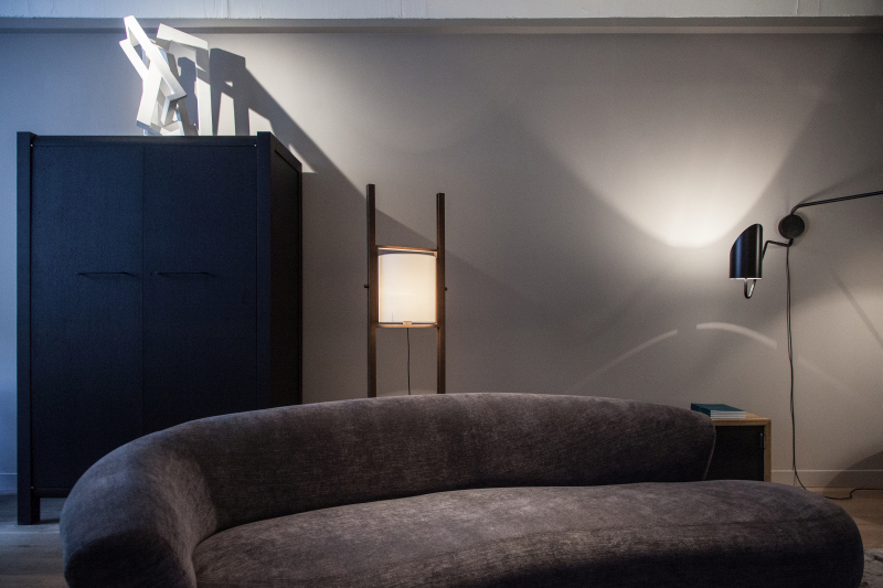 Light Reaches Up the Wall Behind a Curved Sofa