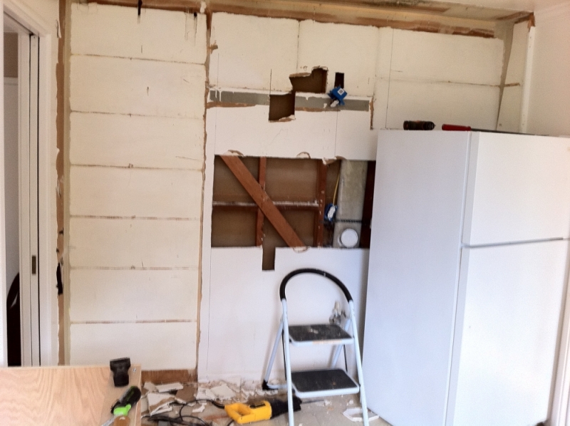 The stove wall was stripped before the new cabinets went in
