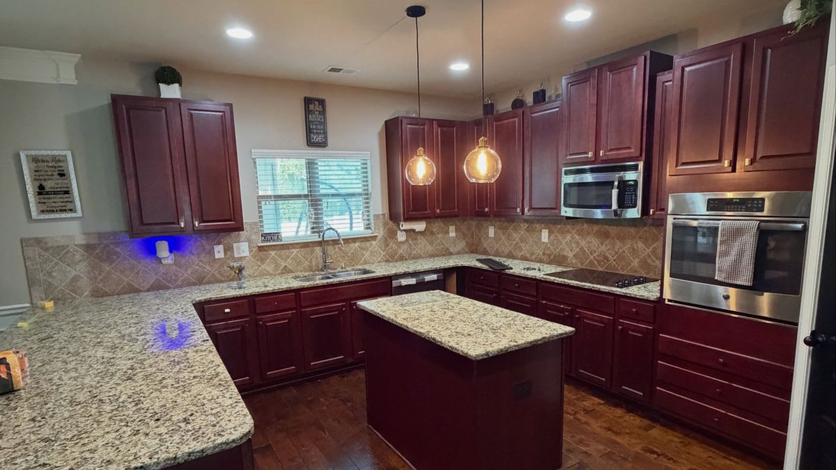 They Spray-Painted the Cherry Cabinets Tricorn Black but Kept the Brown Granite, Tile, and Floors