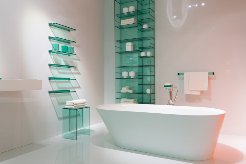 Turquoise Glass Shelves Surround a White Oval Tub