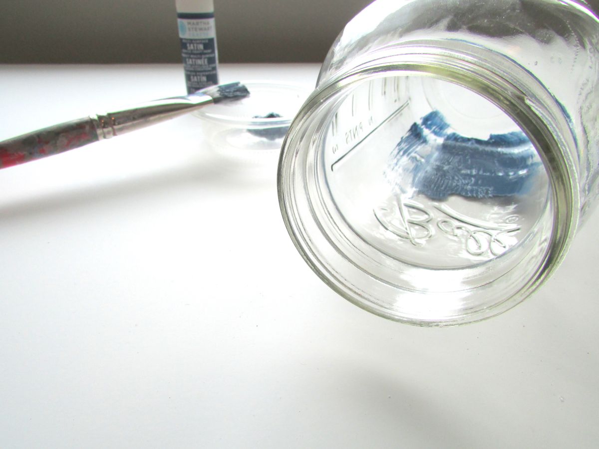 Using a brush inserted through the jar's opening,