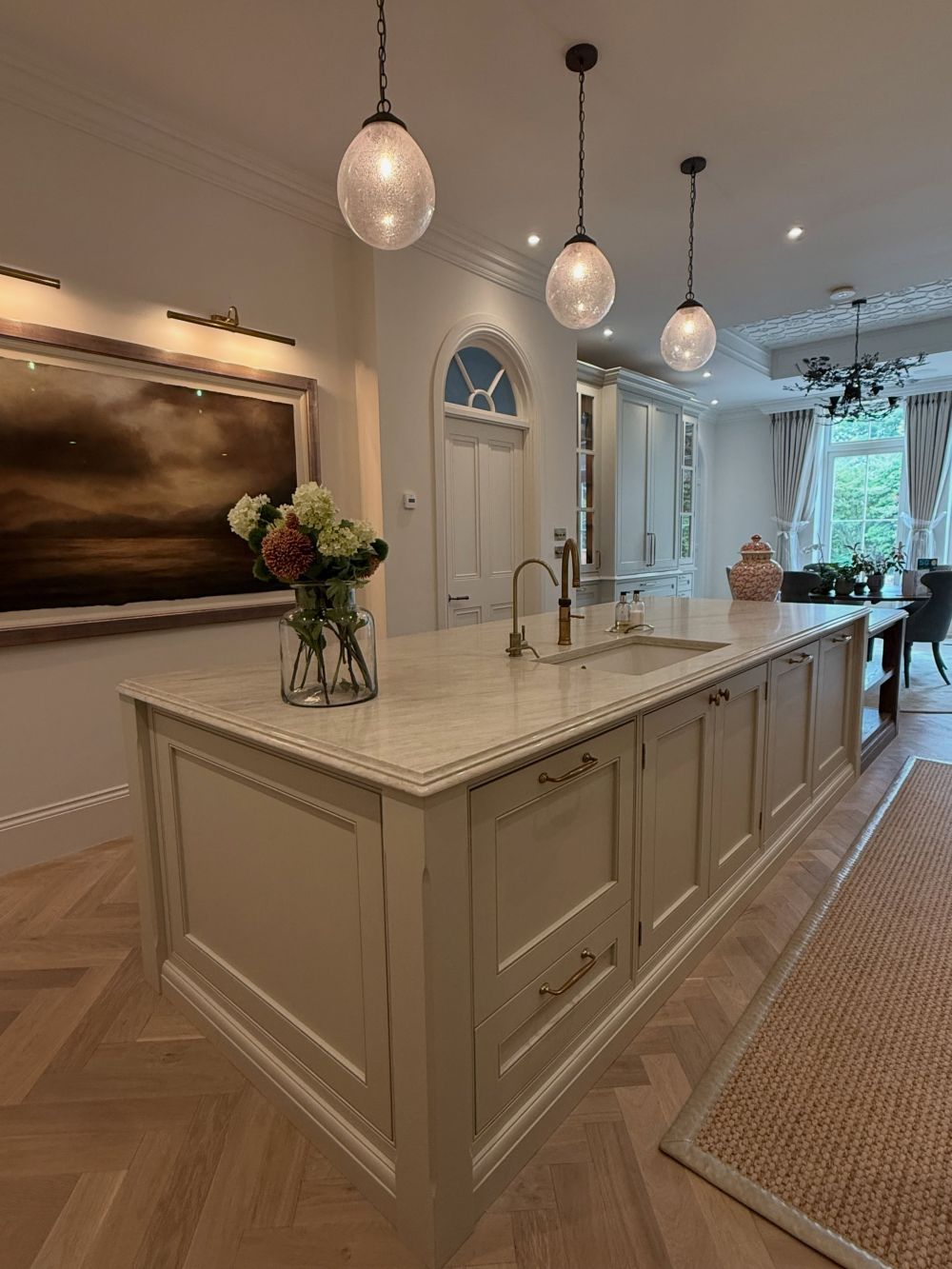 Warm Metal Connects the Painted Doors to the Oak Floor