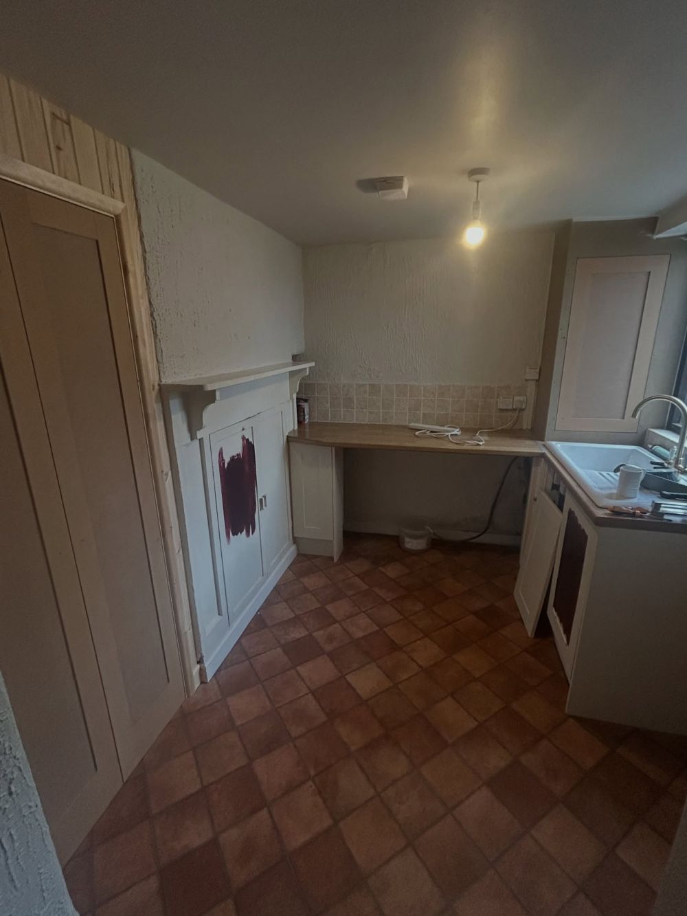 White cupboards and terracotta tones filled the before view