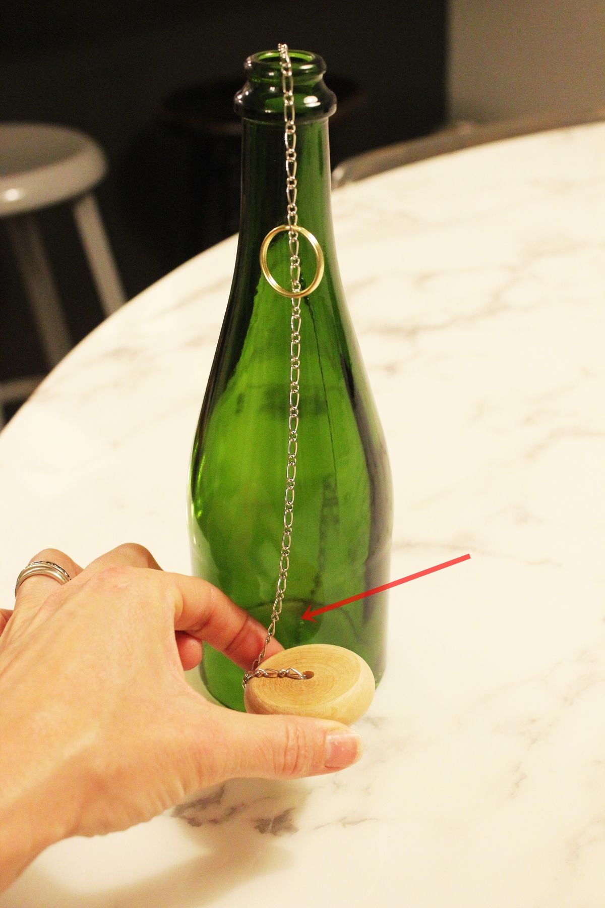 With the chain held beside the bottle,