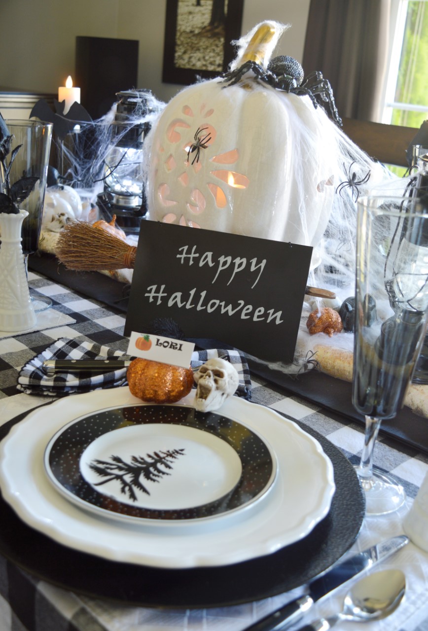 black rat sits on a small white ceramic pumpkin