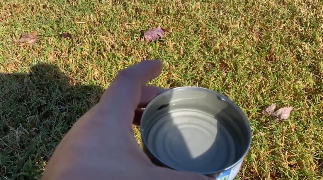 checking-tuna-can-sprinkler-water-on-lawn