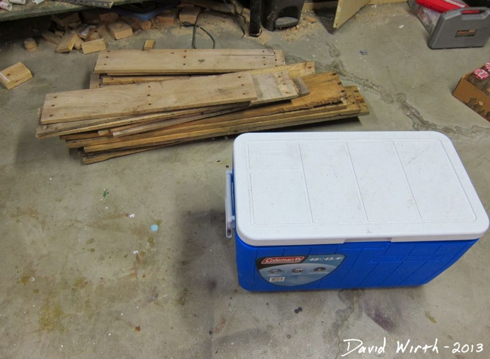 salvaged boards were sorted beside a blue Coleman cooler.